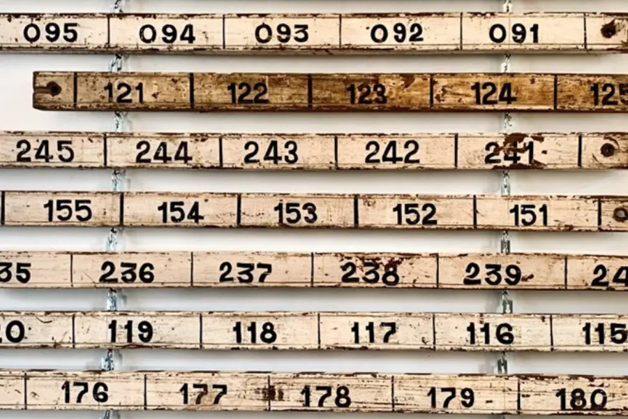 Antique numbered wooden panels displayed as wall art in a curated vintage interior at Circa Warehouse.